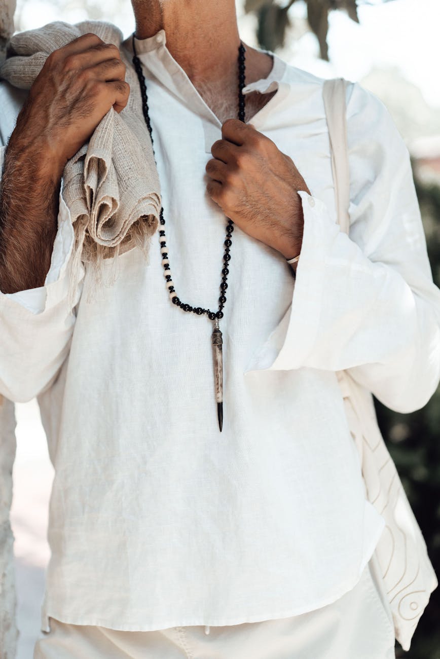 person in white dress shirt wearing beaded necklace